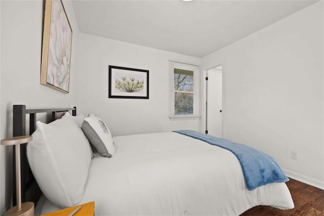 bedroom with baseboards and wood finished floors