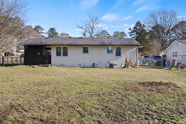 rear view of property with crawl space, a lawn, and fence