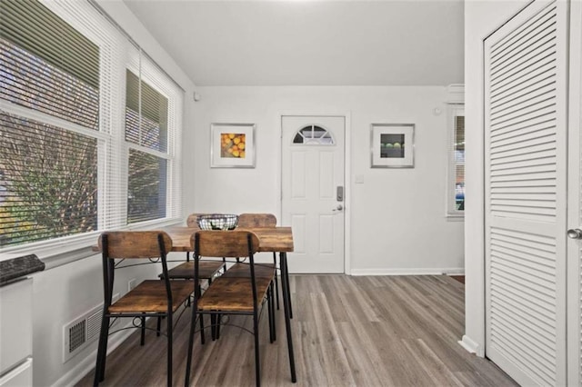 dining room with visible vents, wood finished floors, and baseboards