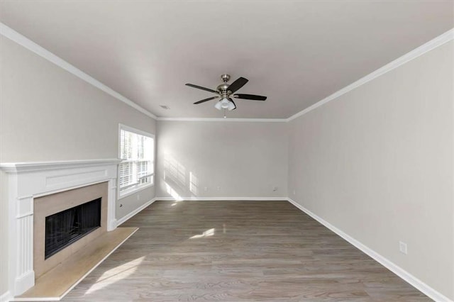 unfurnished living room featuring crown molding, ceiling fan, a fireplace, and hardwood / wood-style floors