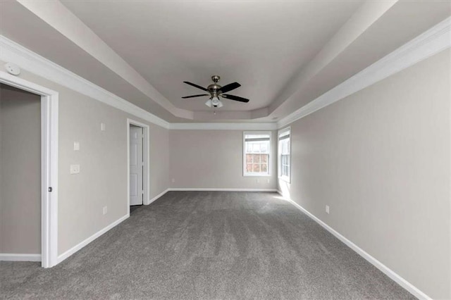 carpeted spare room featuring ornamental molding, a raised ceiling, and ceiling fan