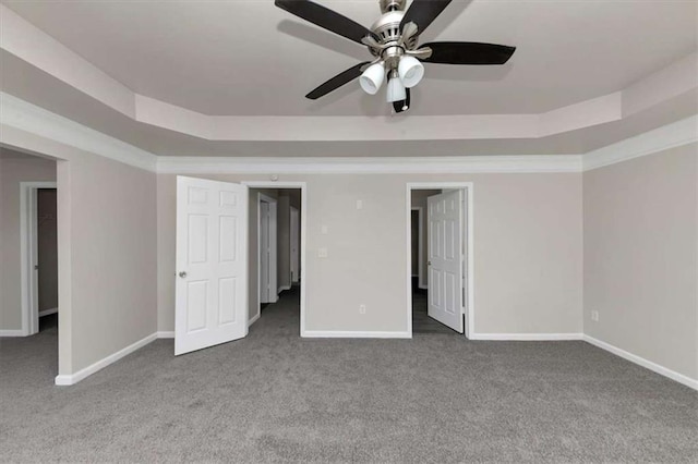 unfurnished bedroom featuring crown molding, a tray ceiling, ceiling fan, and carpet flooring