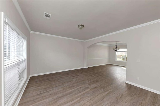 spare room with dark hardwood / wood-style flooring, crown molding, and an inviting chandelier