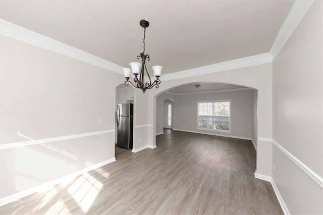 unfurnished dining area featuring ornamental molding, a chandelier, and hardwood / wood-style floors