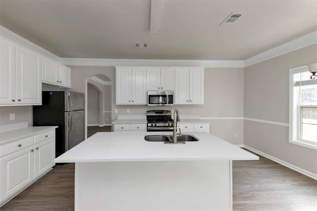 kitchen featuring stainless steel appliances, an island with sink, sink, and white cabinetry