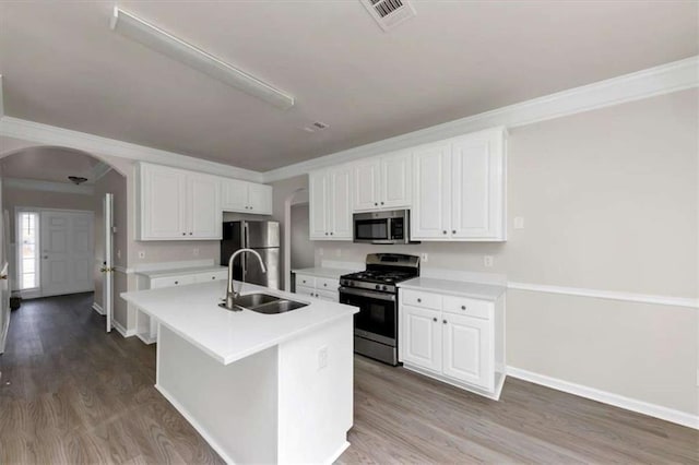 kitchen featuring appliances with stainless steel finishes, white cabinetry, an island with sink, sink, and wood-type flooring