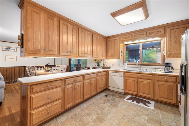 kitchen featuring stainless steel fridge with ice dispenser, sink, kitchen peninsula, and dishwasher