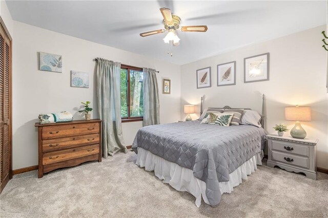 carpeted bedroom featuring ceiling fan and a closet