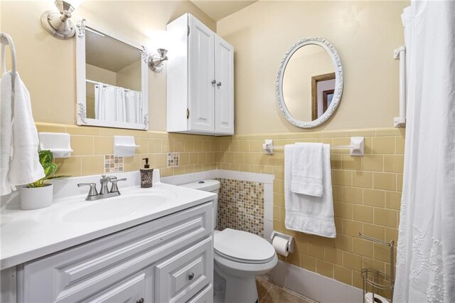 bathroom featuring tile walls, vanity, tile patterned flooring, and toilet