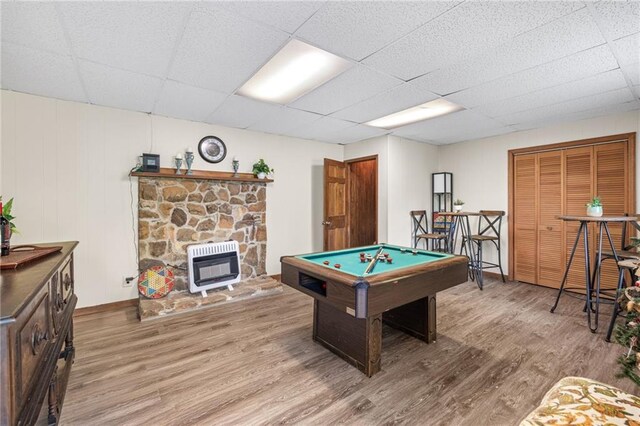 playroom with a paneled ceiling, wood-type flooring, and heating unit