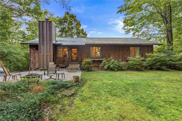 back of property featuring a patio and a lawn