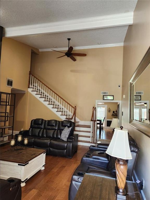 6210 Douglas Manor Ct, Douglasville, GA 30134 - living room with stairs, ornamental molding, wood finished floors, ceiling fan, and a textured ceiling