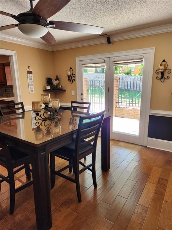 6210 Douglas Manor Ct, Douglasville, GA 30134 - dining area with wood finished floors, crown molding, ceiling fan, and a textured ceiling