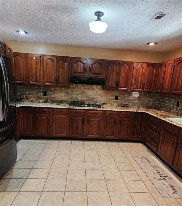 6210 Douglas Manor Ct, Douglasville, GA 30134 - kitchen with under cabinet range hood, decorative backsplash, a textured ceiling, black appliances, and light tile patterned floors