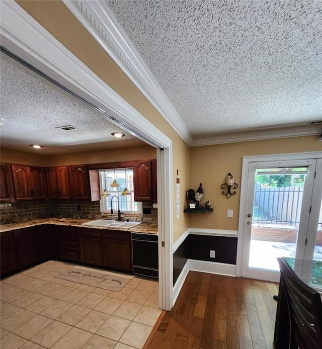 6210 Douglas Manor Ct, Douglasville, GA 30134 - kitchen with a sink, black dishwasher, a textured ceiling, decorative backsplash, and light countertops