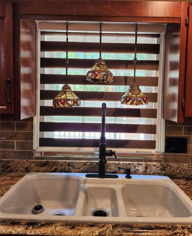 6210 Douglas Manor Ct, Douglasville, GA 30134 - kitchen view of a sink, backsplash, and dark countertops
