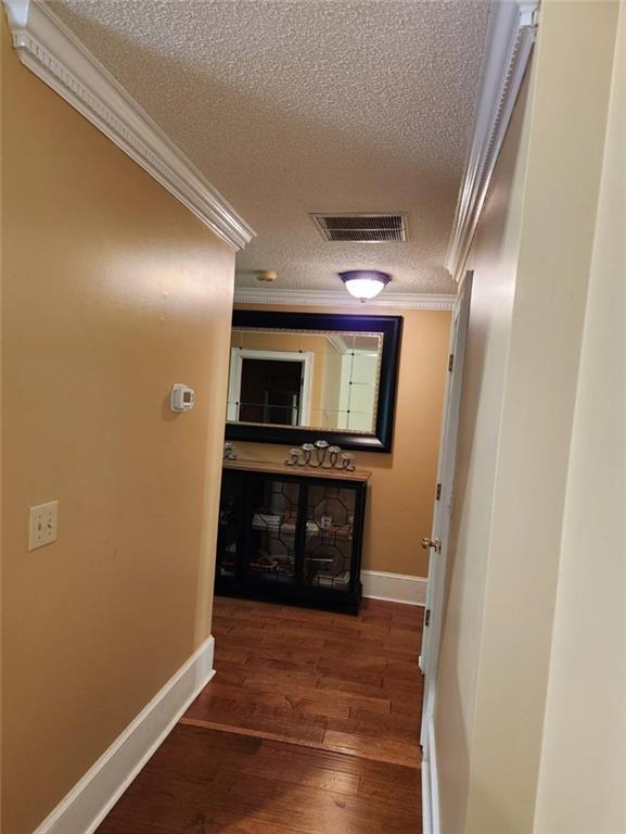 6210 Douglas Manor Ct, Douglasville, GA 30134 - corridor with ornamental molding, a textured ceiling, baseboards, and wood finished floors