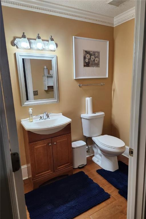 6210 Douglas Manor Ct, Douglasville, GA 30134 - bathroom featuring toilet, vanity, wood finished floors, and a textured ceiling