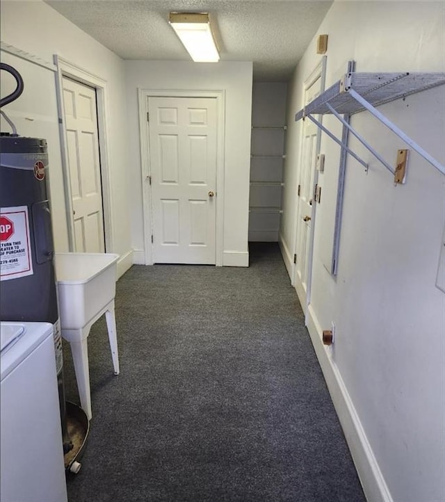 6210 Douglas Manor Ct, Douglasville, GA 30134 - laundry area with water heater, a textured ceiling, dark colored carpet, and baseboards