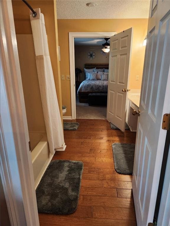 6210 Douglas Manor Ct, Douglasville, GA 30134 - full bathroom featuring wood finished floors, a textured ceiling, ensuite bathroom, shower / bathtub combination with curtain, and ceiling fan