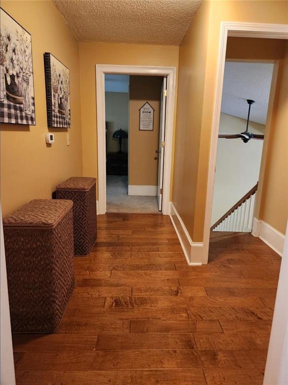 6210 Douglas Manor Ct, Douglasville, GA 30134 - hallway featuring wood-type flooring, a textured ceiling, and baseboards