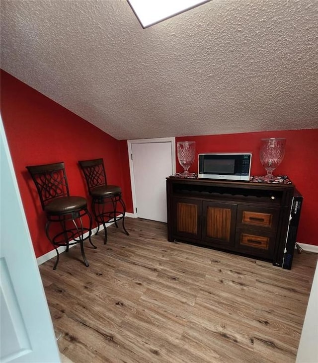 6210 Douglas Manor Ct, Douglasville, GA 30134 - sitting room with a textured ceiling, light wood-style floors, baseboards, and lofted ceiling