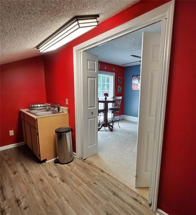6210 Douglas Manor Ct, Douglasville, GA 30134 - bar area featuring a sink, a textured ceiling, light wood-type flooring, and baseboards