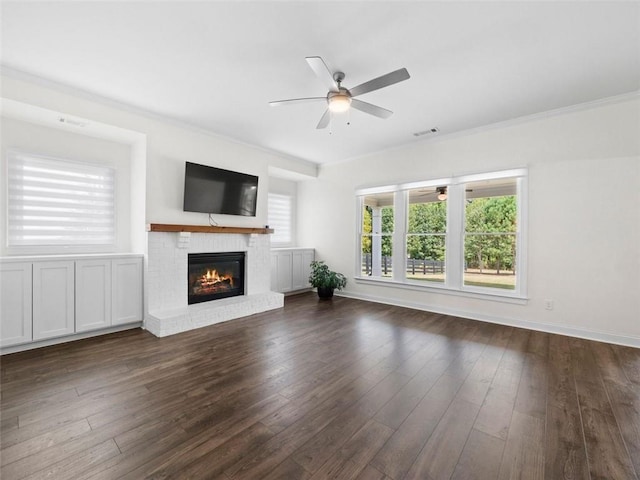 unfurnished living room featuring a fireplace, ceiling fan, ornamental molding, and dark hardwood / wood-style floors