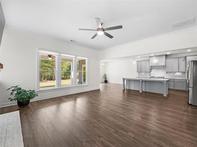 unfurnished living room featuring ornamental molding, ceiling fan, and dark hardwood / wood-style floors