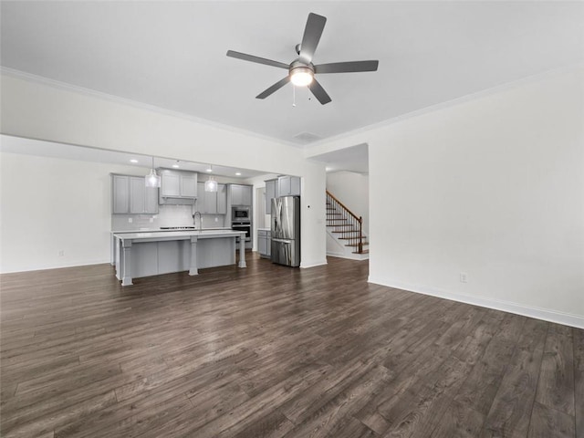 unfurnished living room with ceiling fan, ornamental molding, and dark hardwood / wood-style flooring