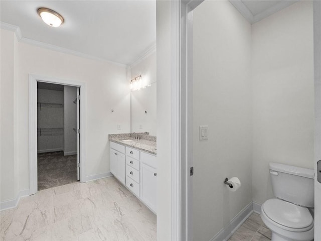 bathroom with ornamental molding, vanity, and toilet