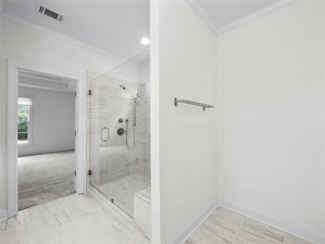 bathroom with a shower with shower door and crown molding