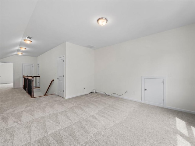 additional living space with vaulted ceiling and light carpet