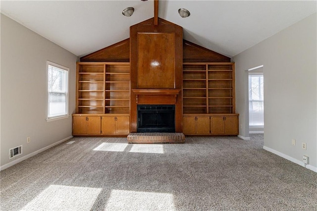 unfurnished living room with light colored carpet, a brick fireplace, built in features, and vaulted ceiling with beams