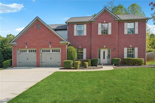 colonial-style house with an attached garage, brick siding, concrete driveway, and a front yard