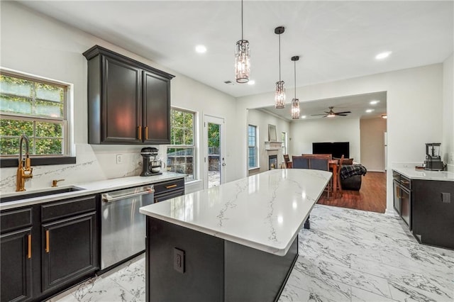 kitchen featuring a fireplace, a kitchen island, a sink, marble finish floor, and stainless steel dishwasher