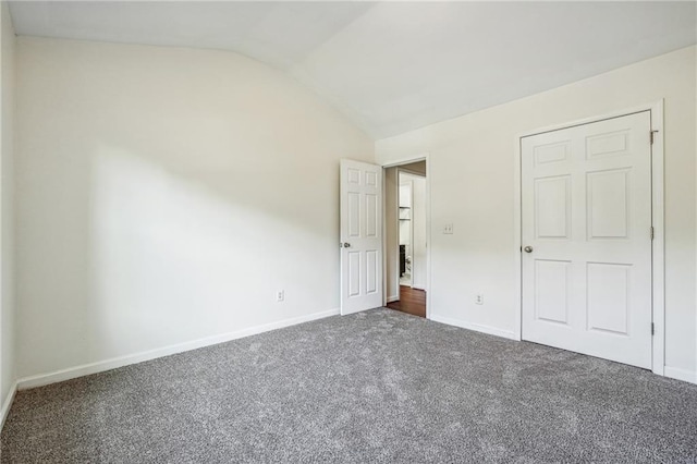 unfurnished bedroom with lofted ceiling, baseboards, and carpet floors