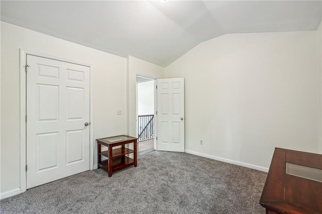 carpeted bedroom with lofted ceiling and baseboards