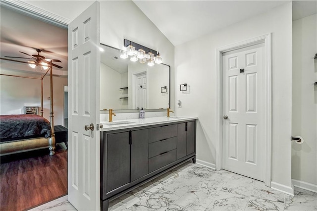 ensuite bathroom featuring ensuite bathroom, marble finish floor, a sink, and baseboards