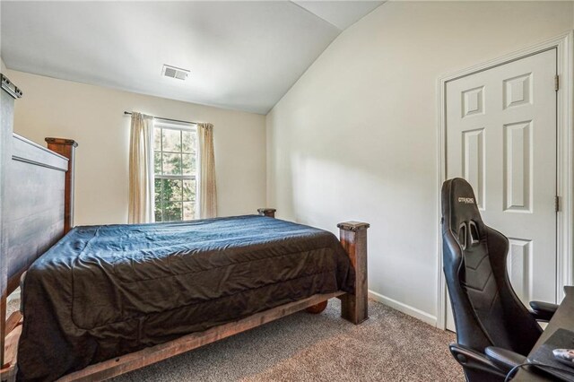 carpeted bedroom featuring lofted ceiling, visible vents, and baseboards