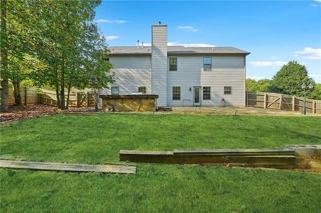 back of house with a patio area, a lawn, a chimney, and a fenced backyard