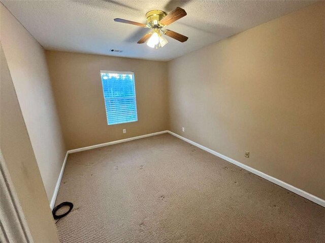 carpeted spare room with ceiling fan and a textured ceiling