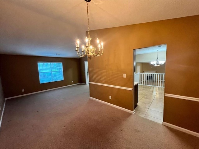 carpeted spare room featuring a notable chandelier