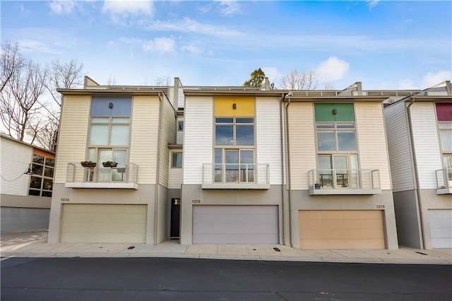 rear view of property with a garage and stucco siding