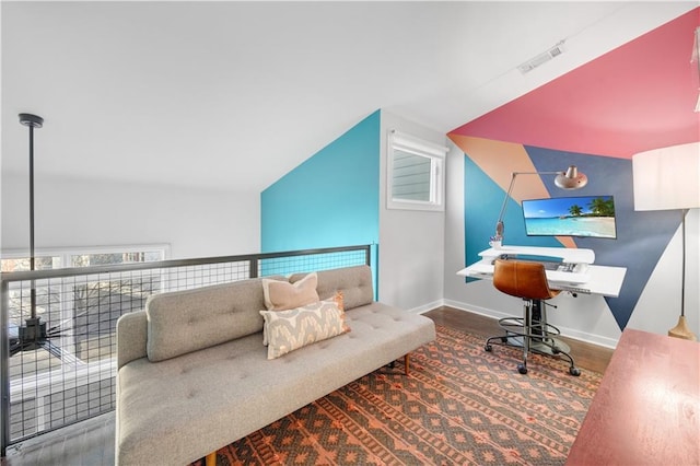 office space featuring lofted ceiling, baseboards, visible vents, and wood finished floors