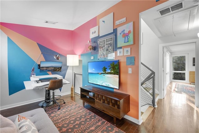 home office featuring baseboards, wood finished floors, visible vents, and attic access