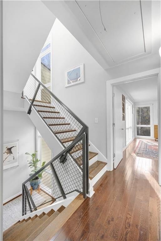 stairway with hardwood / wood-style flooring, attic access, and baseboards