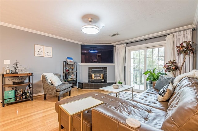 970 Sidney Marcus Blvd Unit 1217, Atlanta, GA 30324 - living area featuring crown molding, wood finished floors, a tiled fireplace, and a textured ceiling