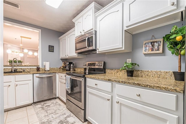 970 Sidney Marcus Blvd Unit 1217, Atlanta, GA 30324 - kitchen featuring white cabinets, visible vents, appliances with stainless steel finishes, a sink, and light stone counters