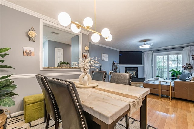 970 Sidney Marcus Blvd Unit 1217, Atlanta, GA 30324 - dining room featuring visible vents, a tile fireplace, crown molding, a notable chandelier, and wood-type flooring